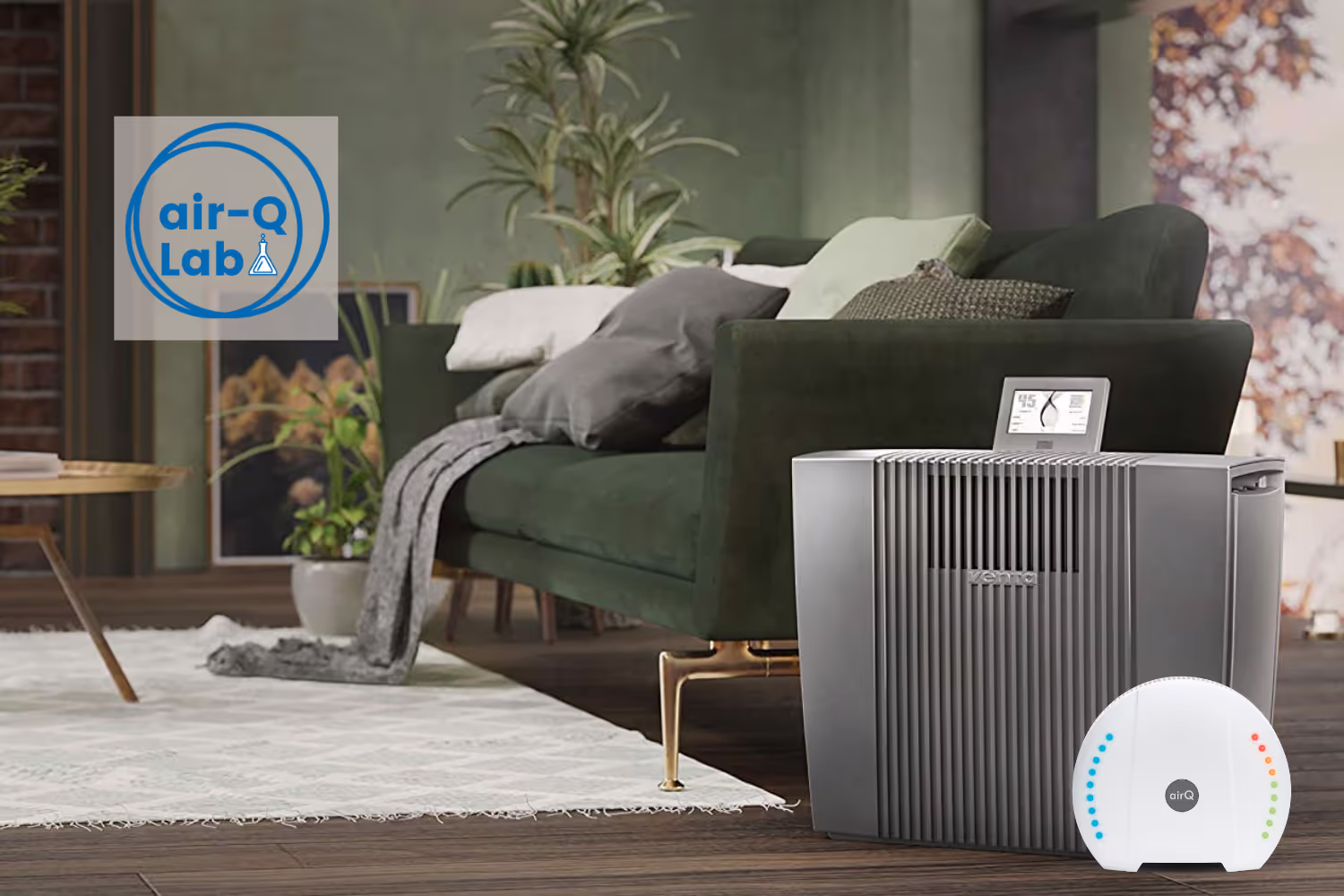 Wohnzimmer mit grünem Sofa. Im Vordergrund stehen der Luftreiniger AH902 K von Venta und ein air-Q.