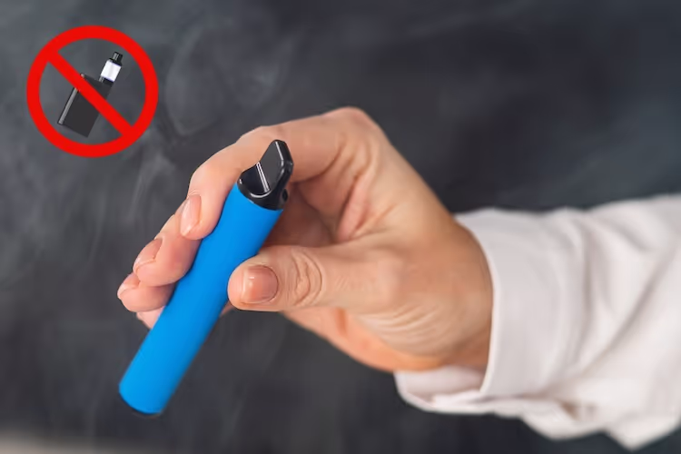 Männliche hand hält eine blaue E-Zigarette, oben links ist das Rauchen-verboten-Symbol