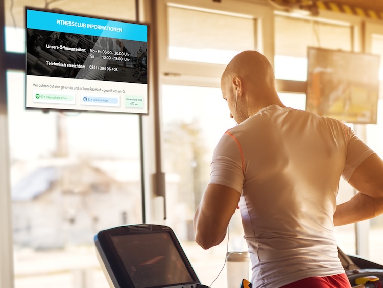 Mann auf einem Laufband, vor ihm ein Monitor, der die Lftqualität mittels air-Q Smart Widgets anzeigt