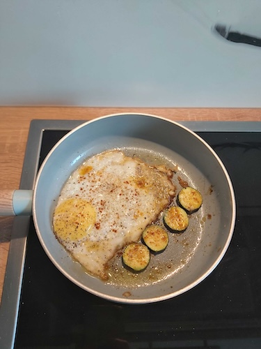 Pfanne mit Spiegelei und gebratenen Zucciniescheiben
